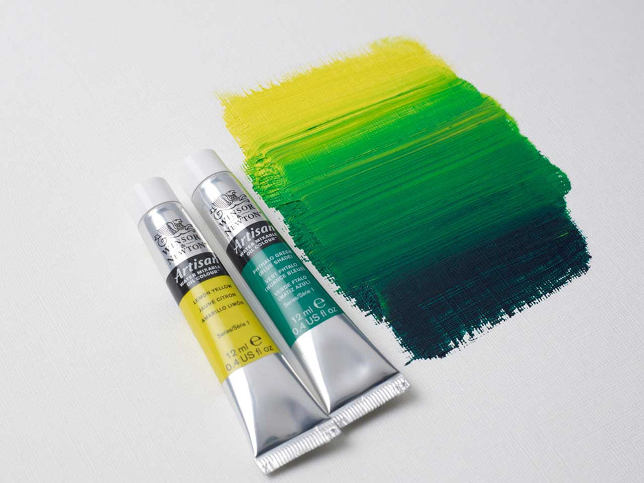 Two tubes of Yellow and Green paint showing coverage on artist canvas